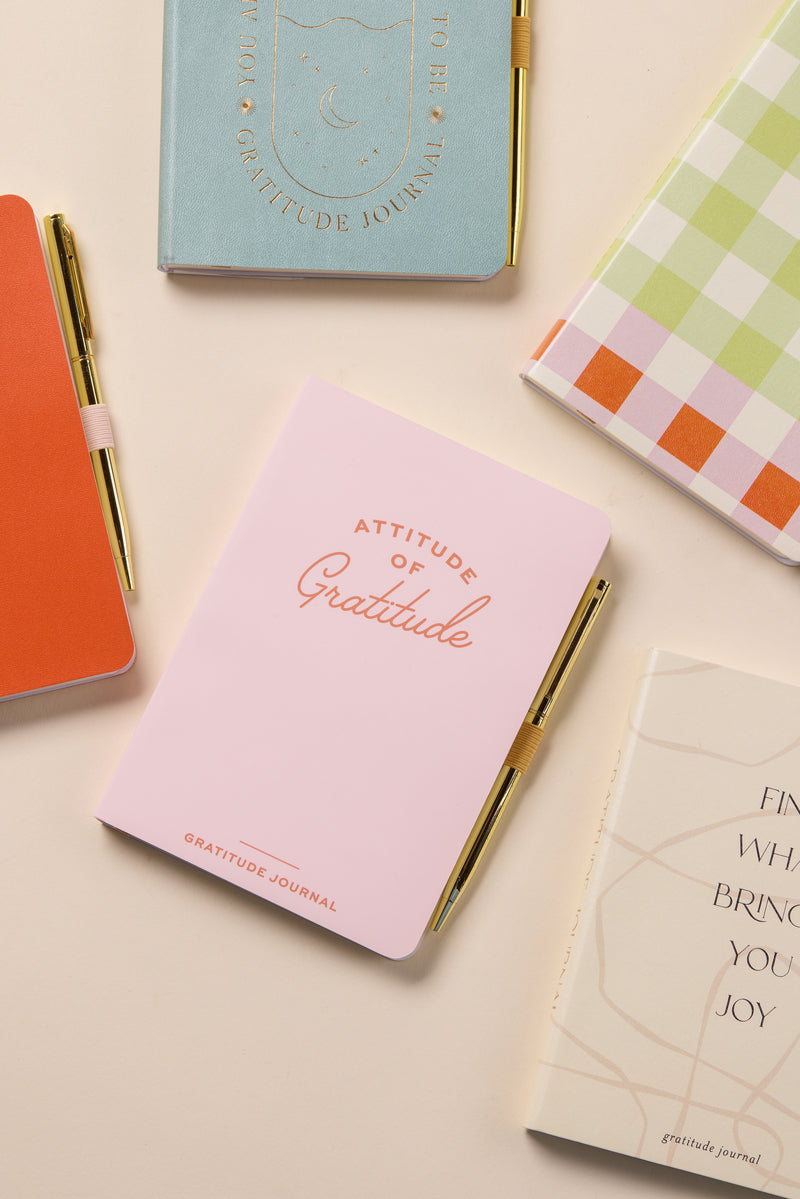 An assortment of colorful notebooks and journals on a desk.