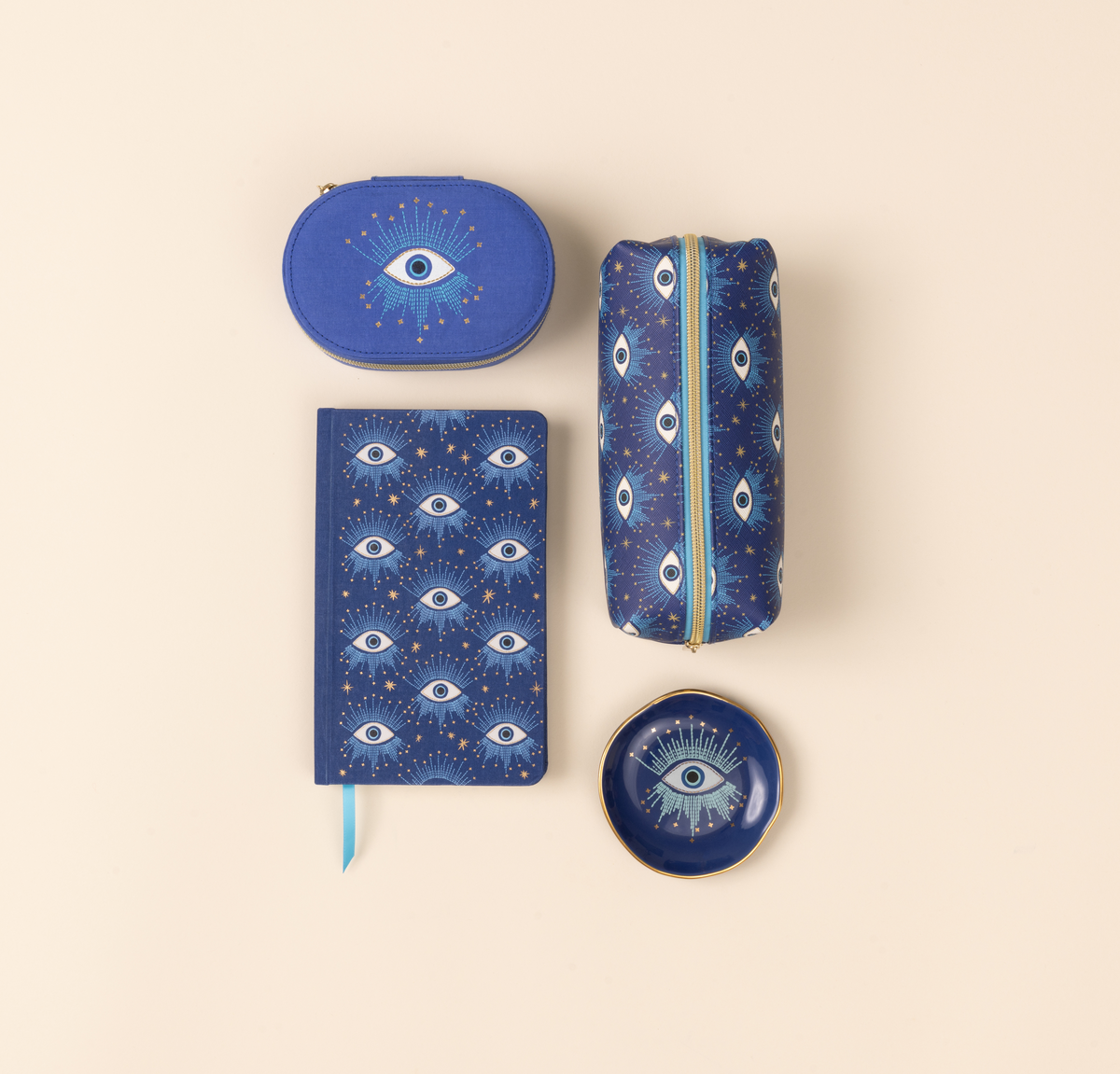 Set of blue pouches and a notebook with eye pattern on beige background