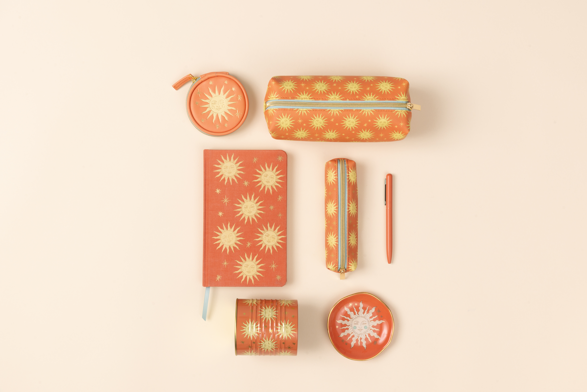 Collection of stationery items with sun design on a beige background