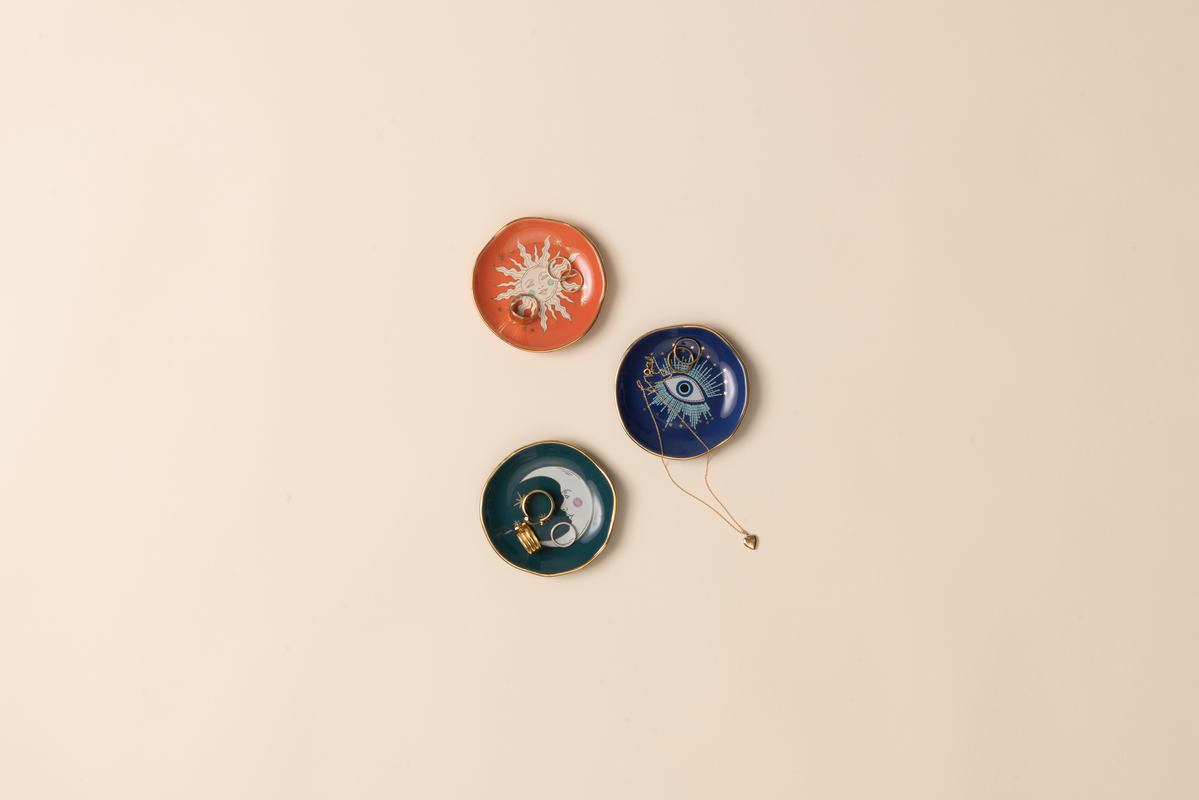 Three decorative dishes with celestial designs on a beige background