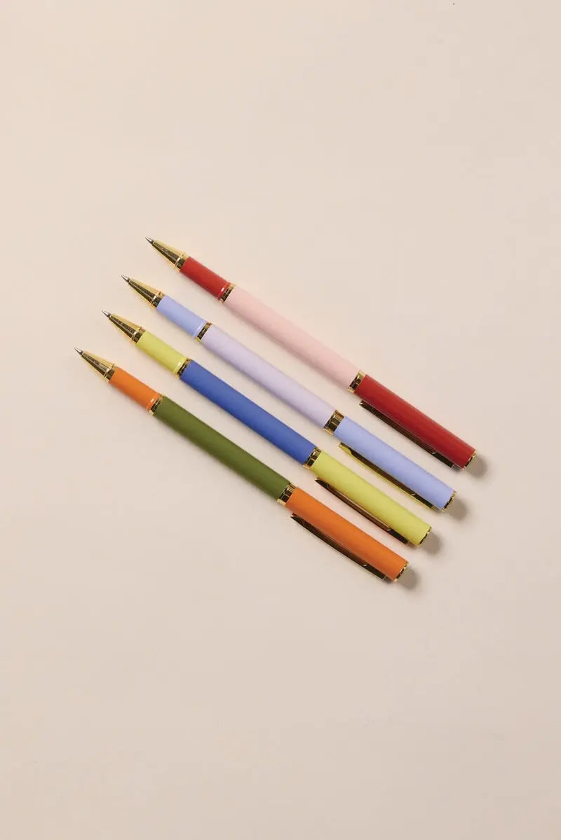 The Color Block Pens - Lavender + Blush set features four luxurious ink pens with matte, two-tone pastel and earthy colorblocked barrels, gold accents, and a stylish design—perfectly arranged on a light beige background.