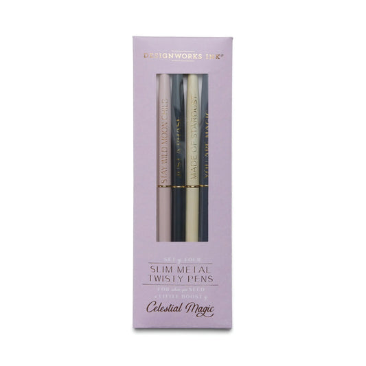 A set of four Slim Metal Twisty Pens - Celestial by DesignWorks Ink in black, silver, gold, and white with gold foil designs, packaged in a purple Celestial Magic box.
