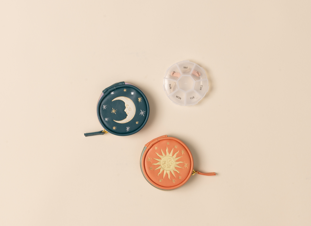 Three small round pouches with celestial designs on a beige background