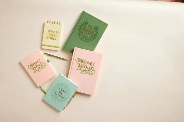 The Vintage Sass Notebook with Pen - Leaf Me Alone is displayed on a light surface, perfect for journal lovers who enjoy unique design, with empty space left on the right.