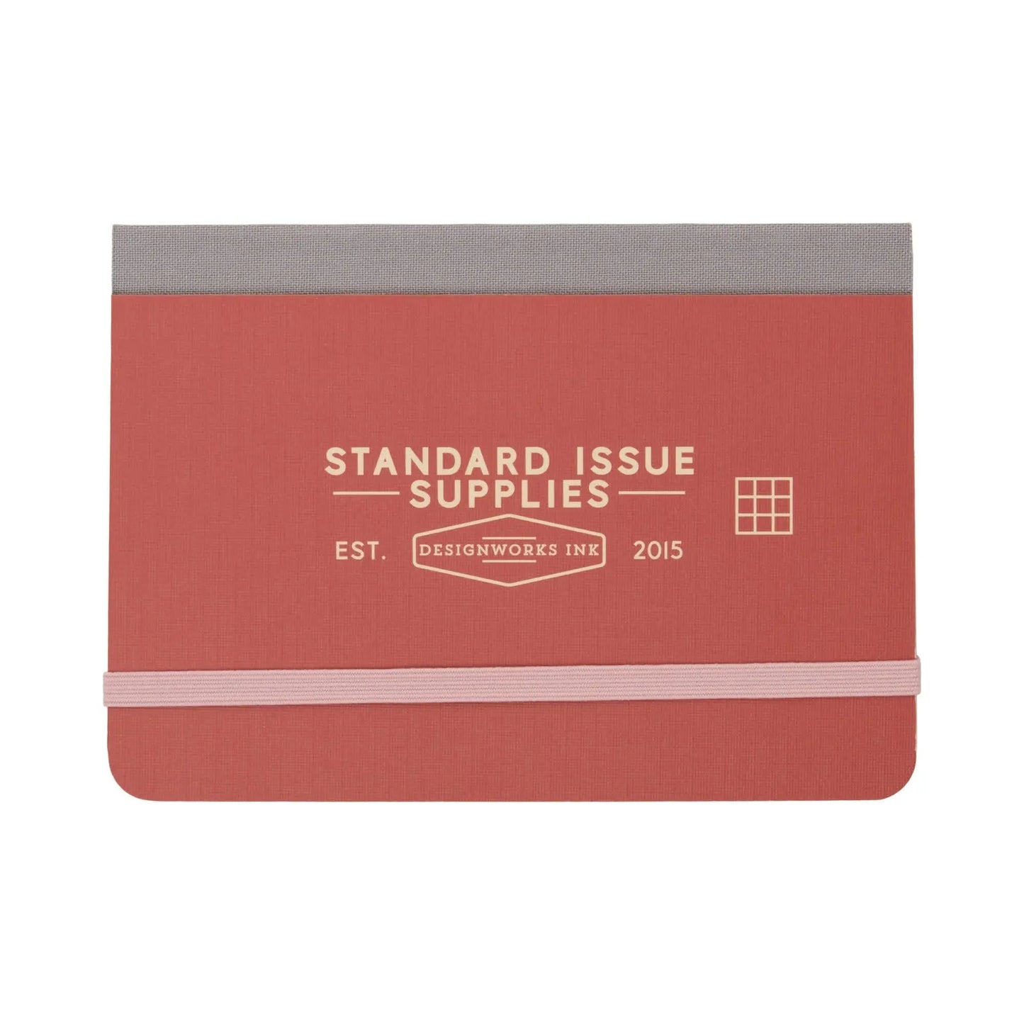 Standard Issue Pocket Journal - Rosewood + Blush by Designworks Ink features an elastic closure, grid pages, and a rectangular grid icon on the cover—perfect for travel notes.