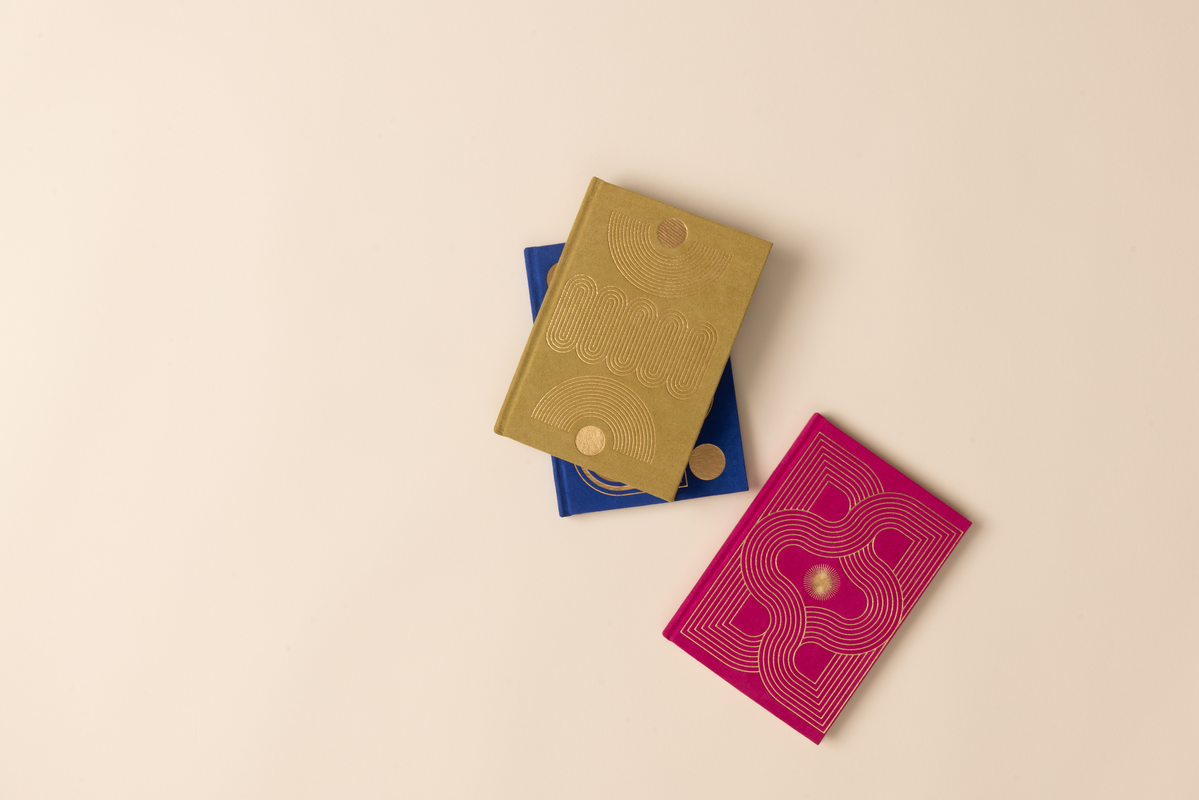 three colorful notebooks on beige background
