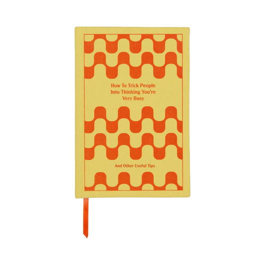The How To Trick People Journal - 5.75x8.5 features a yellow cover with an orange geometric pattern, vintage book-inspired design, the title on the front, and smooth ivory pages inside.