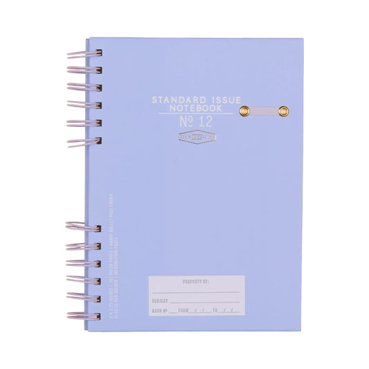 A spiral-bound Standard Issue Planner Notebook No. 12 in Lavender + Periwinkle, featuring high-quality construction and a cover section for subject and owner details.
