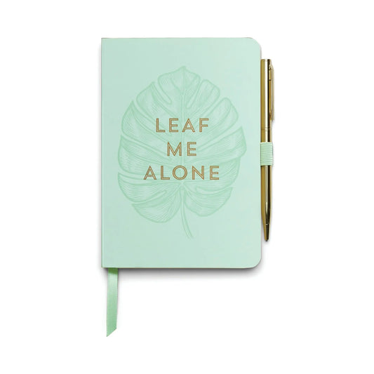 The Vintage Sass Notebook with Pen - Leaf Me Alone features a mint green cover with a unique leaf illustration, gold LEAF ME ALONE text, and an attached gold pen—perfect for stylish note-taking.