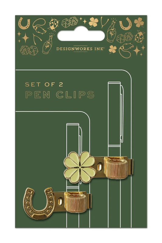 Add charm to your stationery with the Set of 2 Pen Clips - Lucky Charms, featuring gold metal four-leaf clover and horseshoe designs on a green backing card—perfect for enhancing your journaling routine.