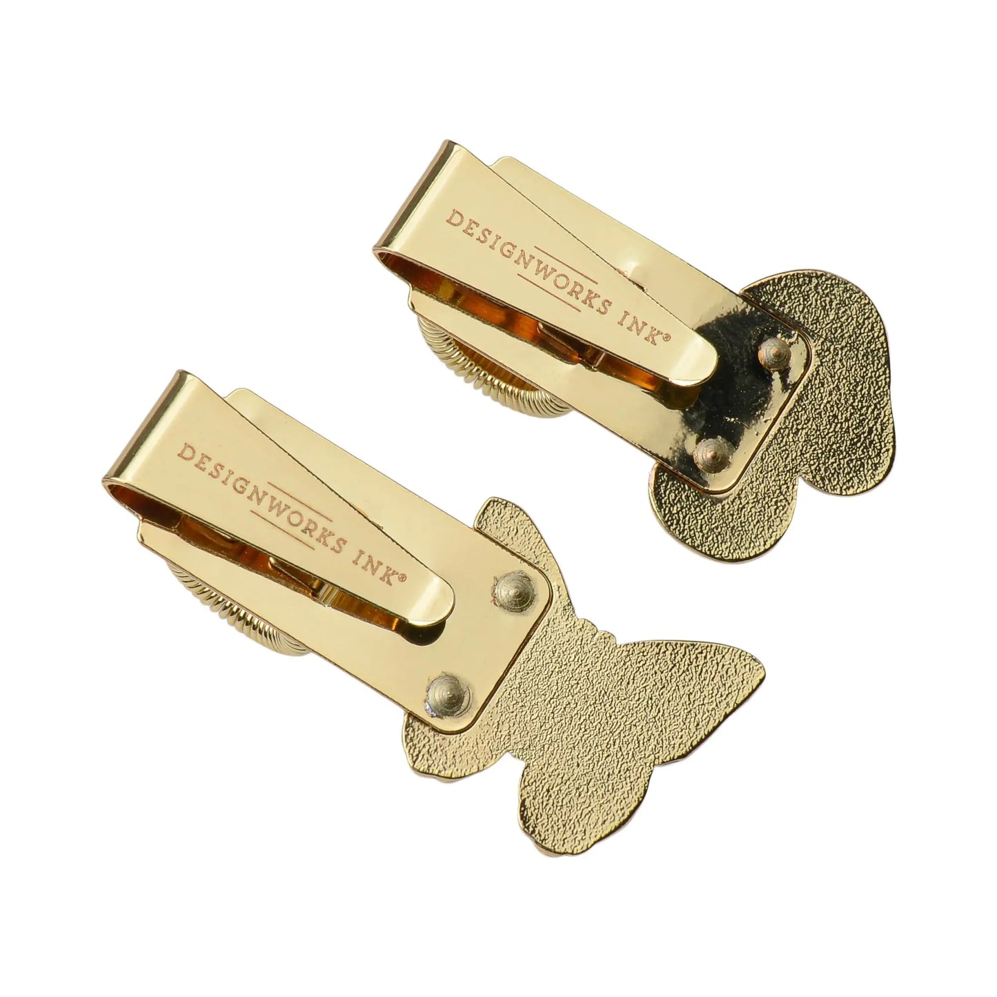 Set of 2 Pen Clips - Butterfly & Mushroom, gold-colored with butterfly-shaped backings and DESIGNWORKS INC® stamped on top—ideal as journaling accessories or to add an enamel icon accent to your planner. Shown on a white background.