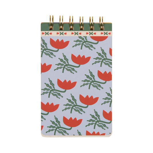 The A Dopo Flower Twin Wire Notepad features a light blue cover with hand-drawn red flowers and green leaves, capturing the charm of Mediterranean travel in a compact spiral design.