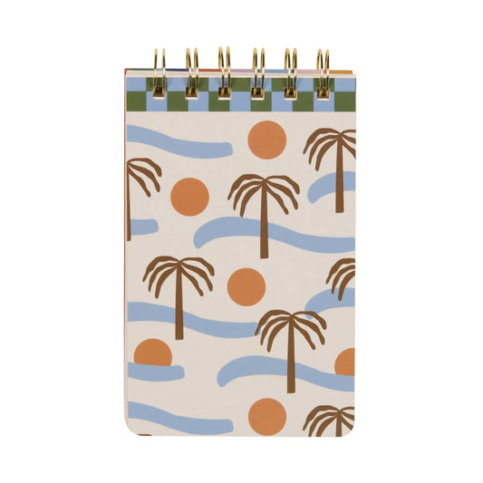 The A Dopo Palm Twin Wire Notepad features a spiral binding and a cover with hand-drawn palm trees, orange circles, and wavy blue lines on a light background, inspired by Mediterranean adventures.