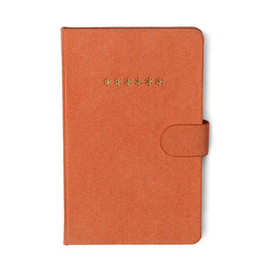 The Mini Password Journal - Asterisks features a closed, textured orange cover with a snap closure and seven gold asterisks embossed on the front—ideal for keeping your confidential login details organized and secure.