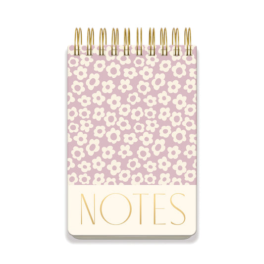 A large chunky notepad with a lilac groovy floral cover, spiral-bound, and featuring NOTES in bold gold letters at the bottom.