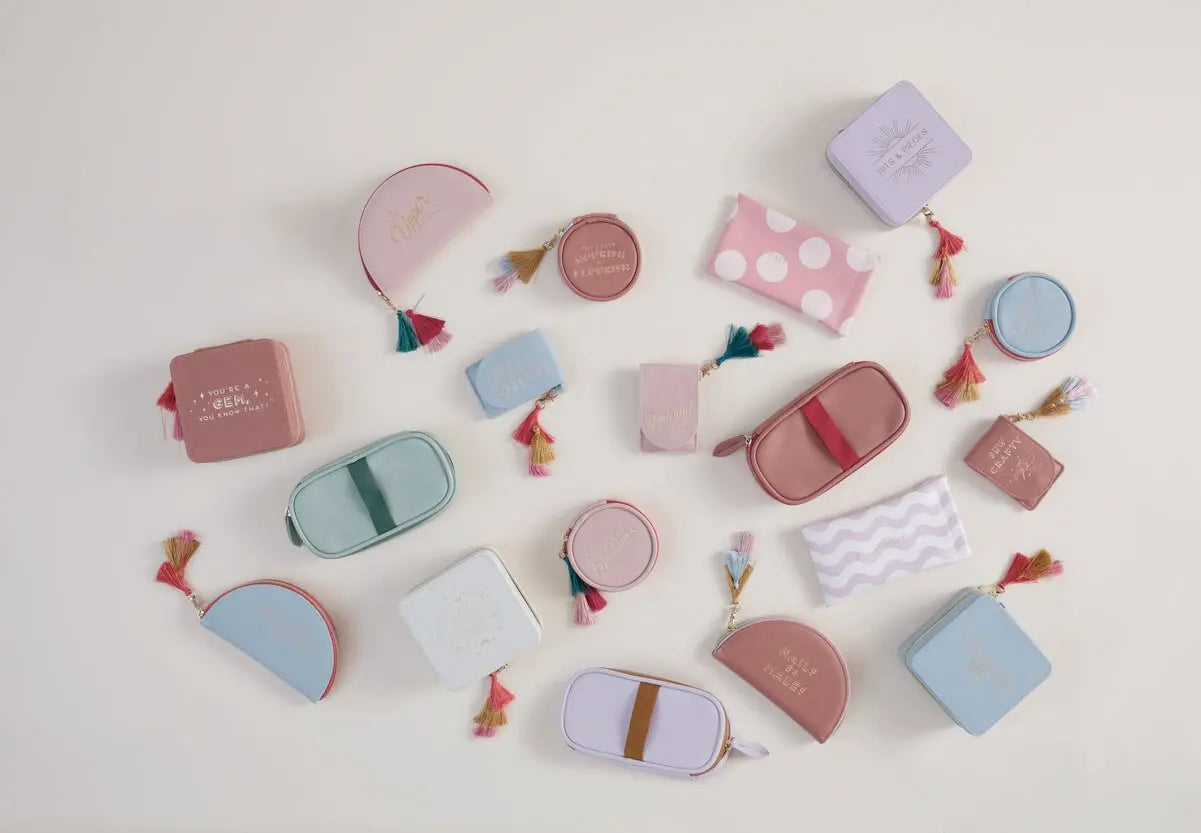 Assorted pastel makeup and accessory bags with tassels, in various shapes and sizes, arranged on a light surface—ideal companions for your Vegan Leather Travel Pill Case with Tassel - Daily Vital-Mins.