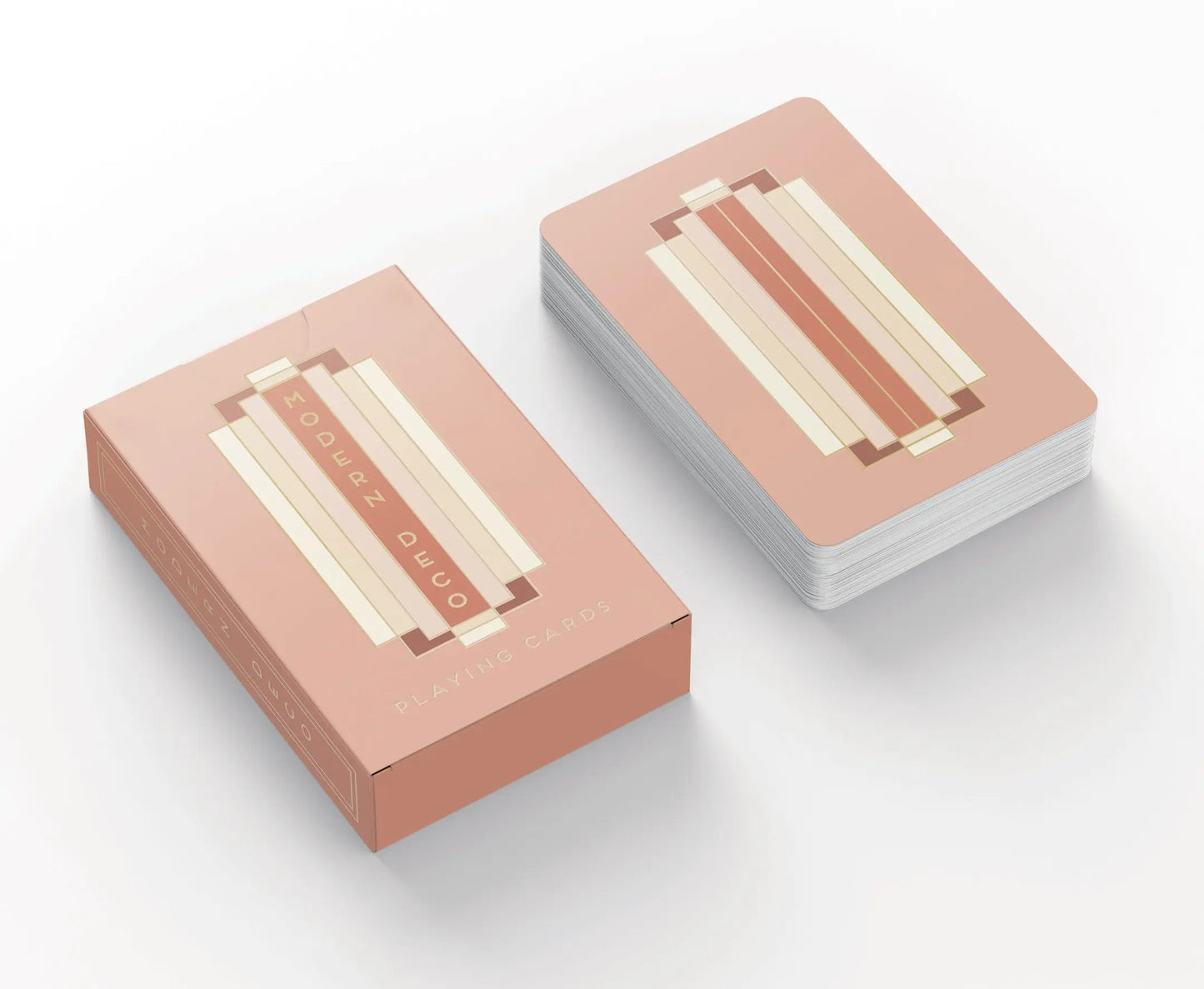 A deck of Playing Cards - Modern Deco with a geometric art deco design in pink, beige, and cream. The box features gold foil stamping and Modern Deco Playing Cards on the front.