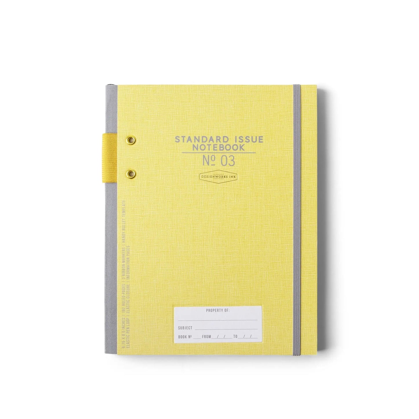 The Standard Issue Notebook No.3 - Ochre is a closed yellow notebook with a gray spine and elastic band, labeled on the cover, featuring hand-sewn binding and a blank white label at the bottom.