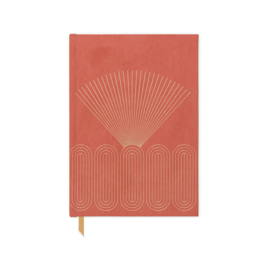The Hard Cover Suede Cloth Journal with Pocket - Radiant Rays features a coral cover with a gold geometric design, lined pages, a ribbon bookmark, and is displayed on a white background.