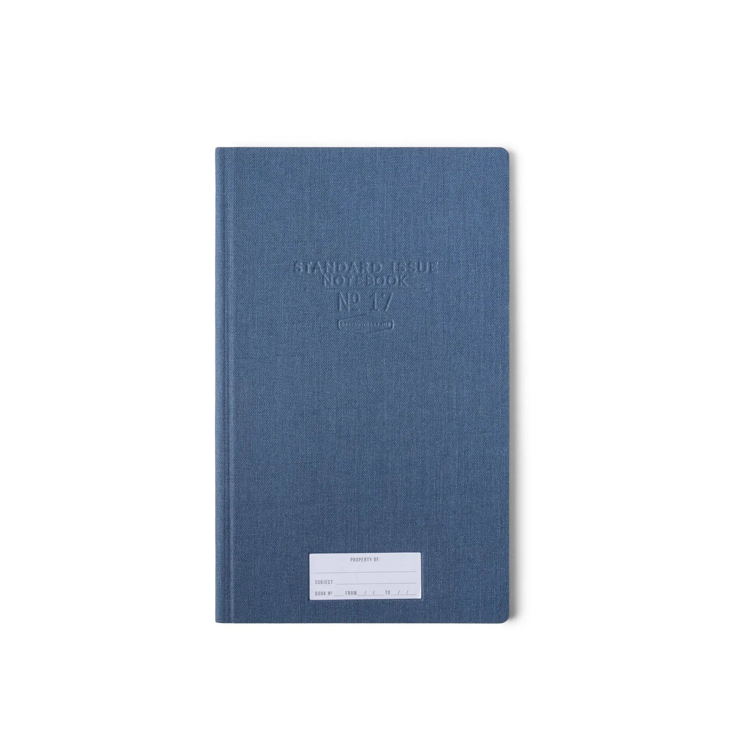 The Standard Issue Tall Notebook No.17 - Blue, featuring a durable hardcover and white label, stands out against the plain white background, highlighting the premium craftsmanship of Standard Issue notebooks.