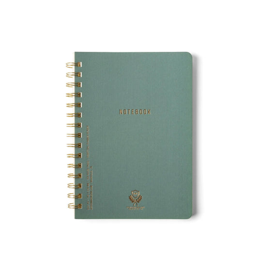 The Textured Paper Twin Wire Notebook - Medium Juniper is a green, spiral-bound notebook with gold NOTEBOOK lettering, a small emblem on the lower front cover, and a flexible soft cover, shown on a white background.