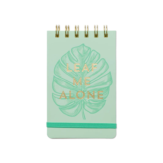 The Vintage Sass Notepad - Leaf Me Alone features a green spiral binding, a bold leaf design, gold LEAF ME ALONE text, and a green elastic band—a perfect pick for plant lovers with vintage flair.