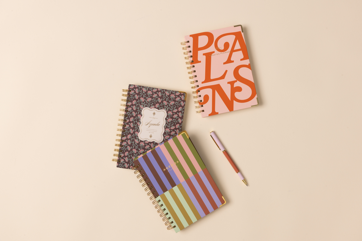 Three notebooks with different designs on a beige background