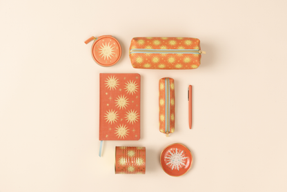 Collection of stationery items with sun design on a beige background