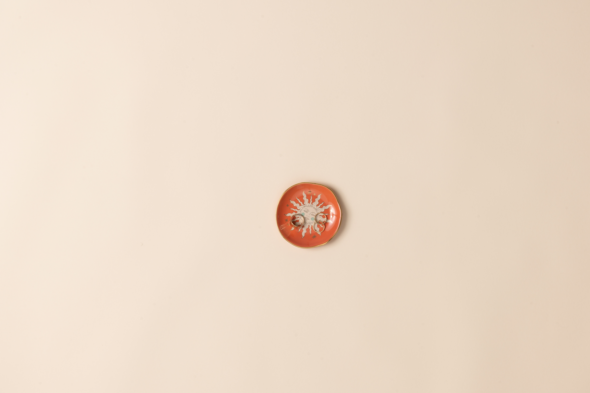 Small orange decorative dish on a beige background