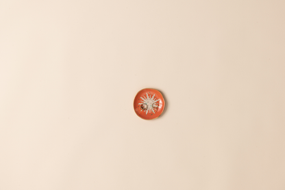 Small orange decorative dish on a beige background