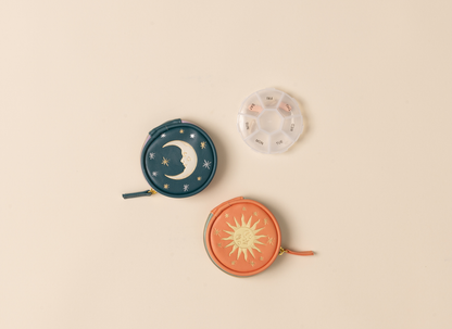 Three small round pouches with celestial designs on a beige background