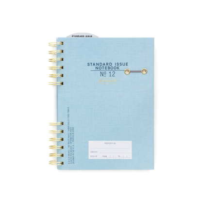 The Standard Issue Notebook No.12 - Blue is a spiral-bound, light blue notebook with gold binding, two metal rivets, a white label, and a top tab—ideal as a premium writing journal.