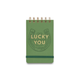 The Vintage Sass Notepad - Lucky You is a green spiral notebook with twin wire binding, featuring a gold horseshoe and the phrase “Lucky You” embossed on the cover. An elastic band wraps around the bottom, adding both charm and practicality to this retro-inspired notepad.