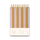 The Chunky Large Twin Wire Notepad features a hard cover with vertical lilac and ochre stripes, lined sheets for easy writing, and "NOTES" printed in bold gold letters at the bottom of the cover.