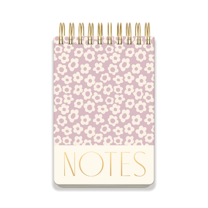 A chunky large twin wire notepad with a lilac groovy floral cover design and "NOTES" in bold gold at the bottom, featuring lined pages for convenient writing.