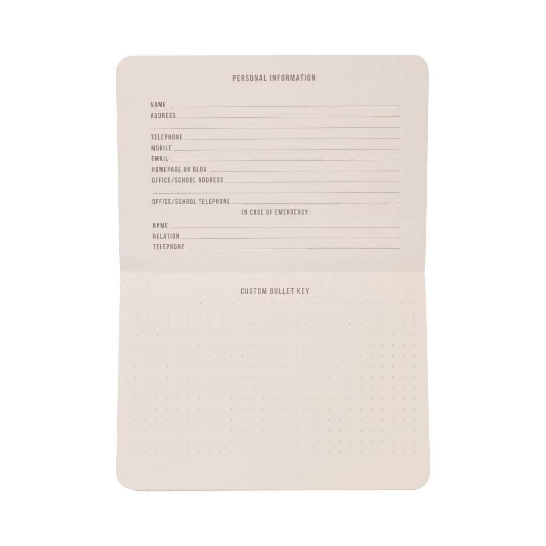 The Standard Issue Pocket Journal - Black features sections for personal information, emergency contacts, and a customizable bullet key on dotted paper. With blank pages ready to be filled in, it’s perfect for use as a travel journal or for daily note-taking.