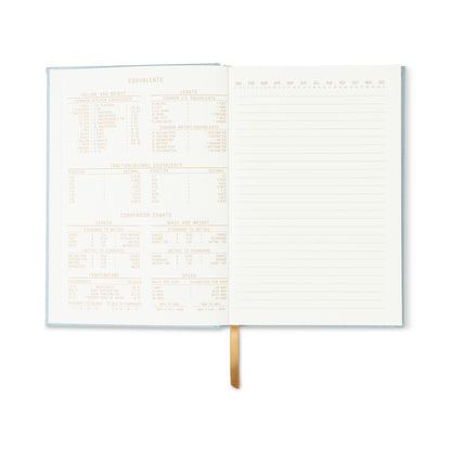 The Hard Cover Suede Cloth Journal With Pocket - Arch Dot features blue suede, conversion charts and equivalency tables on the left page, lined writing space on the right, and a gold ribbon bookmark in the center.