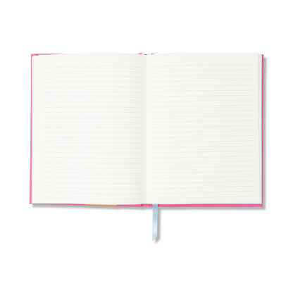 The A Dopo Sun Journal is an open pink lay-flat journal with lined pages and a light blue ribbon bookmark, displayed on a white background. Its blank pages make it a perfect gift for writers.