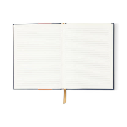 The A Dopo Moon Phases Journal features an open lined notebook with a dark cover and two ribbon bookmarks—one pink and one gold—lying flat on a white background, perfect for use as a moon phases or astrology journal.
