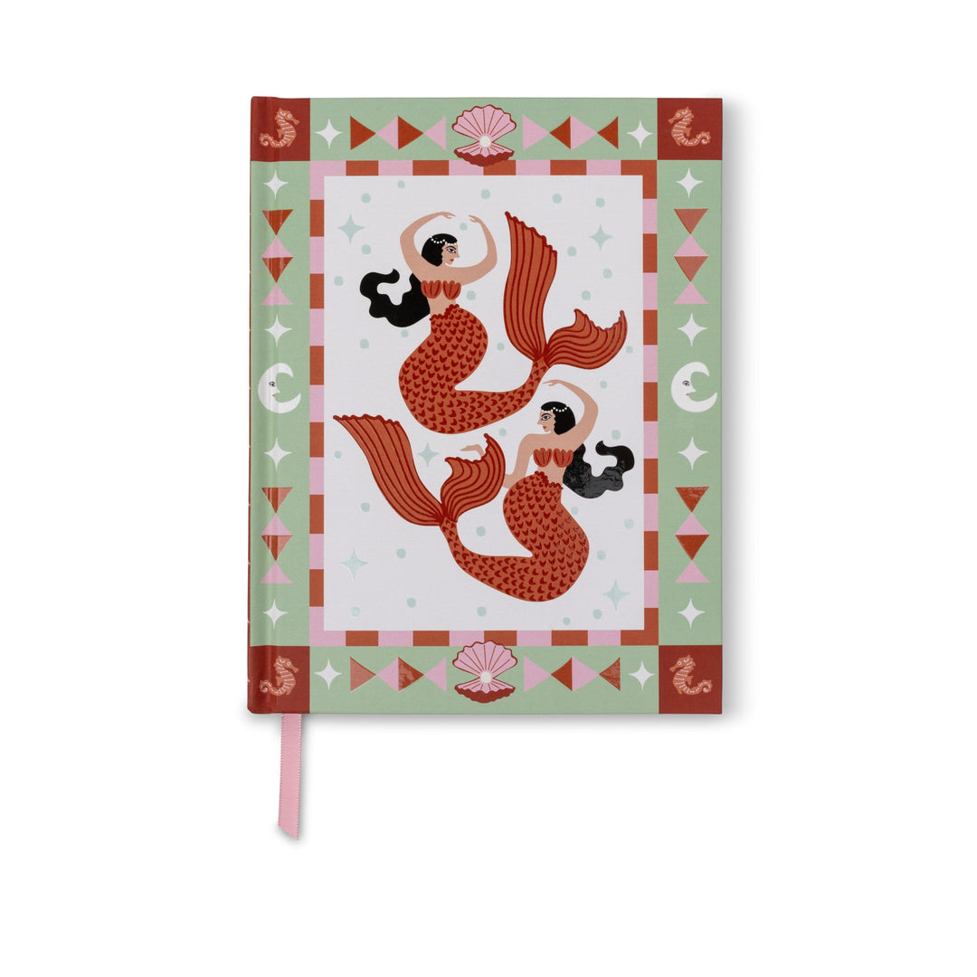 A hardcover notebook featuring a mermaid illustration on the cover, with a pink ribbon bookmark hanging from the bottom edge, set against a plain white background.