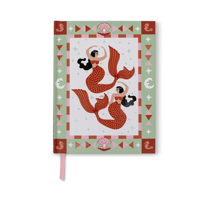 A hardcover notebook featuring a mermaid illustration on the cover, with a pink ribbon bookmark hanging from the bottom edge, set against a plain white background.
