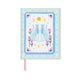 The A Dopo Blue Cheetah Journal features a light blue cover illustrated with two blue cheetahs sitting back to back amid pink flowers, crescent moons, stars, and a sun. Crafted with eco-friendly materials and a lay-flat binding for comfortable writing, it also includes a pink ribbon bookmark visible at the bottom.
