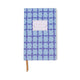 The Tulip Journal - Blue Lattice features a geometric dark blue pattern, a blank white label on the cover, lay-flat binding, and a brown ribbon bookmark.
