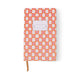 The Tulip Journal - Orange Check is a vibrant writing journal with an orange and pink geometric cover, a blank white label at the top center, orange ribbon bookmark, and a white background.