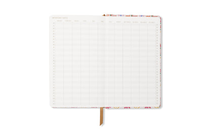 The Tulip Journal - Tropical is an open floral notebook with two blank, grid-layout pages for monthly date tracking, a ribbon bookmark, and a patterned border.