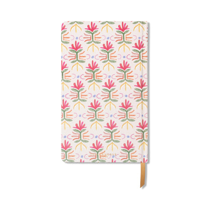 The Tulip Journal - Tropical is a rectangular notebook with a white cover decorated with pink, green, and yellow abstract tulips, and includes a brown ribbon bookmark attached at the bottom.