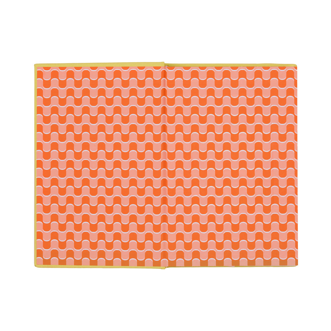 The open How To Trick People Journal features a bookcloth cover and pages adorned with a repeating wavy orange and white pattern, bordered by a yellow edge, displayed on a white background.