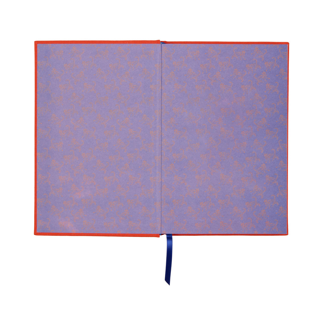 The “Reasons Why I Would Rather Be A Cat Journal” is an open vintage book journal with purple patterned endpapers featuring small animal motifs, an orange border, and a blue ribbon bookmark. The lay-flat binding ensures easy writing and seamless use.