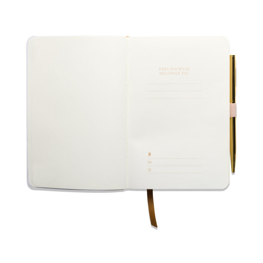 Experience the Gratitude Journal with Pen - Pause: an open mindfulness journal featuring blank, cream-colored pages and a pen neatly tucked into a loop on the right side. Inside, dedicated space labeled “This journal belongs to:” allows for personalization, while a brown ribbon bookmark rests across the bottom page.