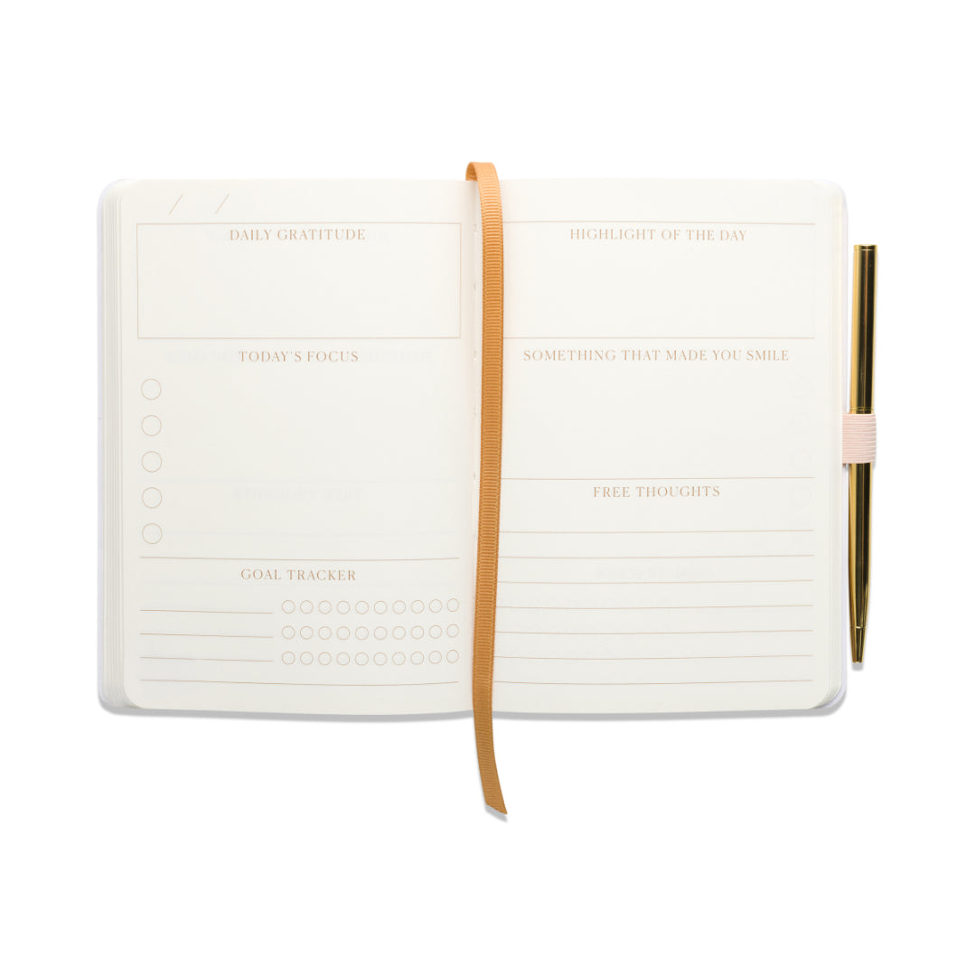 Introducing the “Gratitude Journal with Pen - Pause”: an inviting guided journal featuring a tan ribbon bookmark, elegant gold pen, and thoughtfully labeled sections for gratitude, focus, goals, highlights, smiles, and free thoughts. With mostly blank pages, it’s perfect for beginning your mindfulness journal practice.